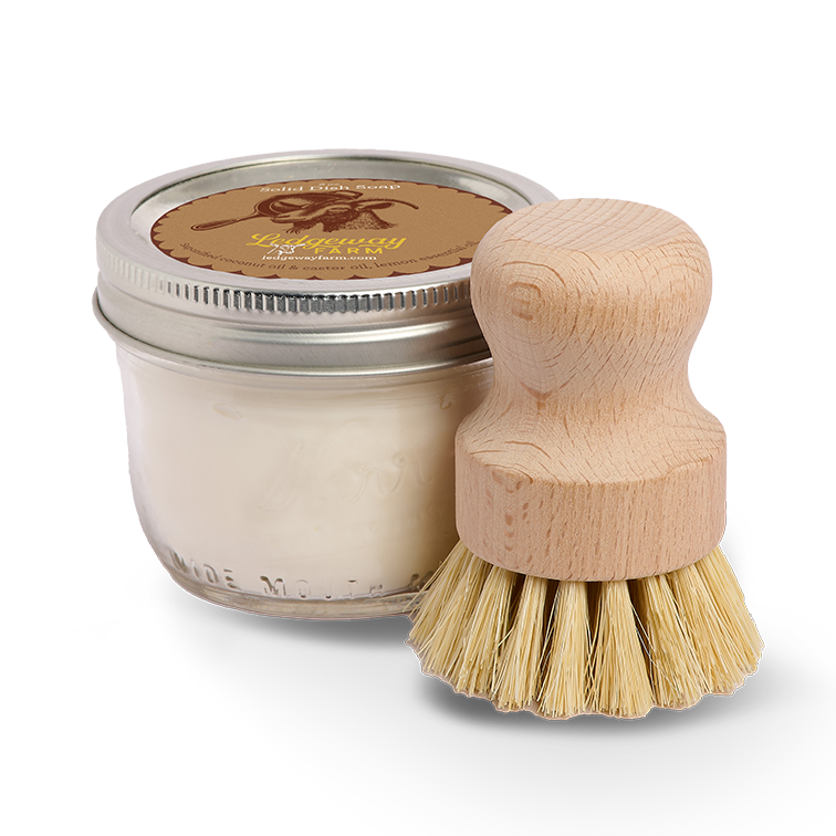 Jar of dish soap and wooden brush on a white background
