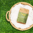 Basket with laundry detergent and white towels on grass